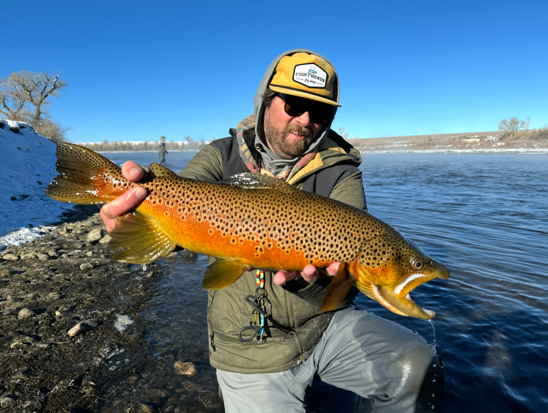 Guide holding a trophy brown trout on a Utah river